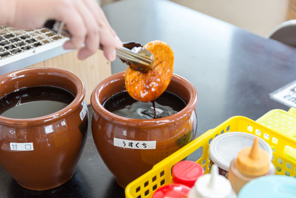 煎餅に醤油をつける様子