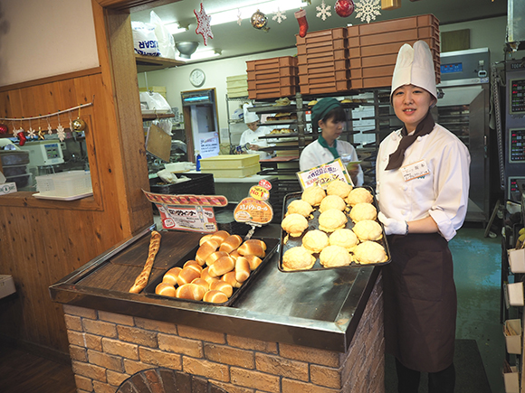 焼きたてのメロンパンを運ぶ店員