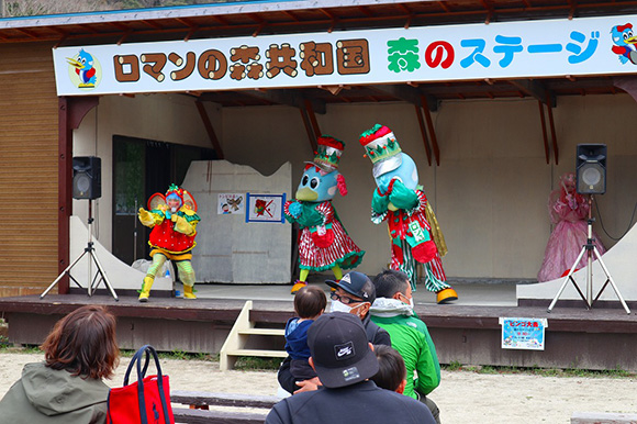 ステージで踊る青い鳥のキャラクター