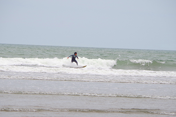 波に乗りサーフボードに立つ男性