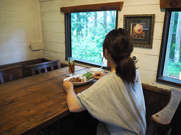 カレーを食べる女性の後ろ姿