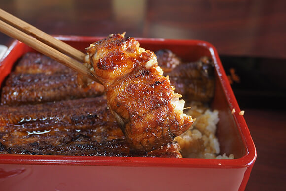 箸で持ち上げた肉厚なうなぎ