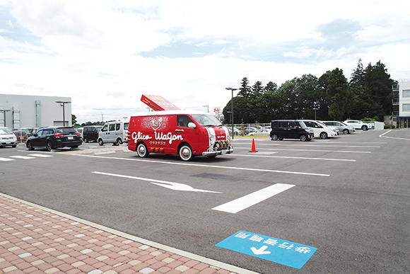 駐車場にとめる赤いワゴン