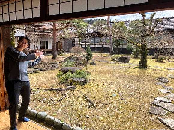 庭の方を示す男性