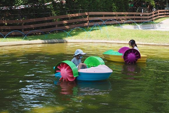 池のボートで遊ぶ子供