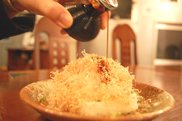 揚げ餅に醤油をかける場面