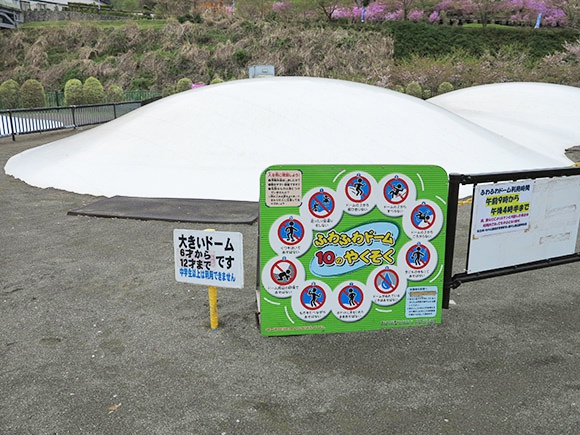 緩やかな傾斜の2つの白いドームと看板