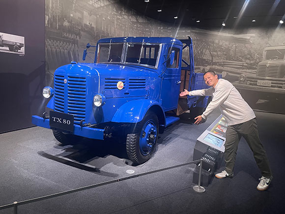 いすゞの青い旧車と男性