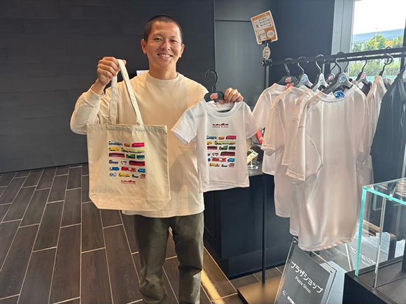 バッグや服を手に持つ男性