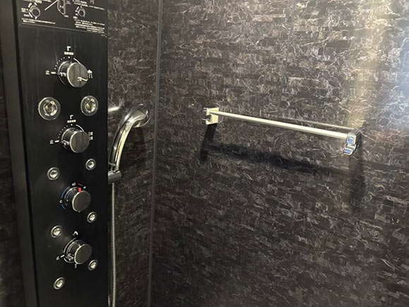 銀色のシャワーヘッドとダイヤル