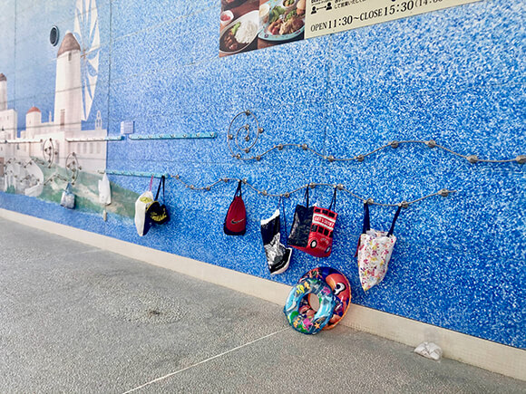 青い壁に掛けられたタオルや荷物
