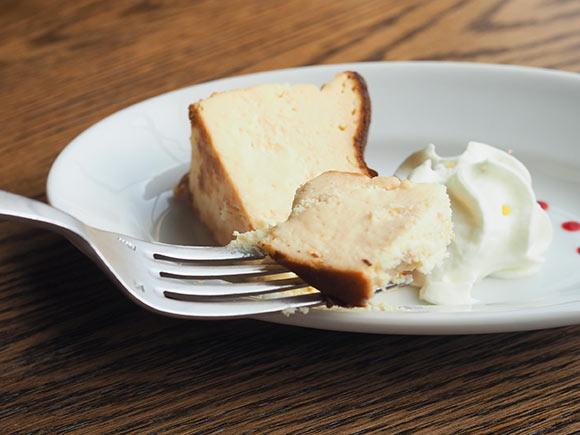フォークで持ち上げられたチーズケーキ