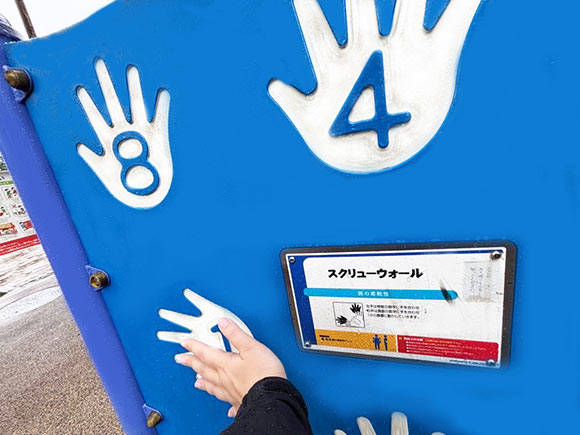 手のマークと数字が書かれた青い壁