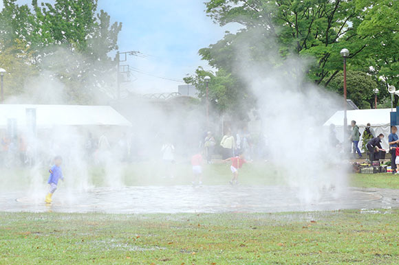 ミスト噴水の中で遊ぶ子ども達