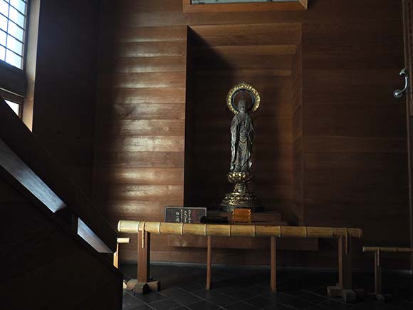 薄暗い建物の中に祀られた聖観音立像