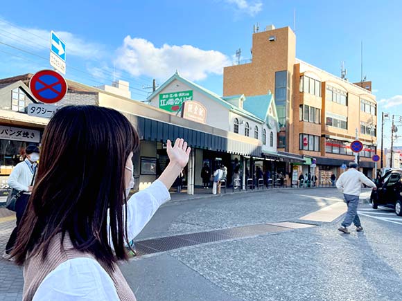 手で鎌倉駅西口を示す女性