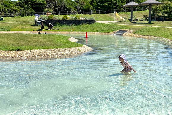 透き通った水の池で遊ぶ子ども