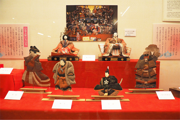 赤い雛壇に飾られた6体の人形