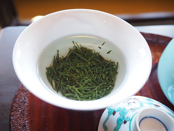 お湯に沈む緑の茶葉