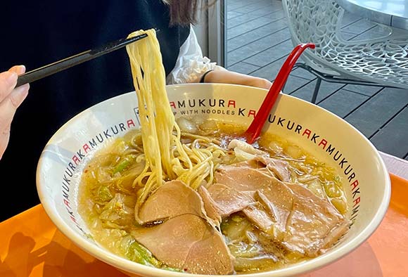 麺を箸で持ち上げる女性