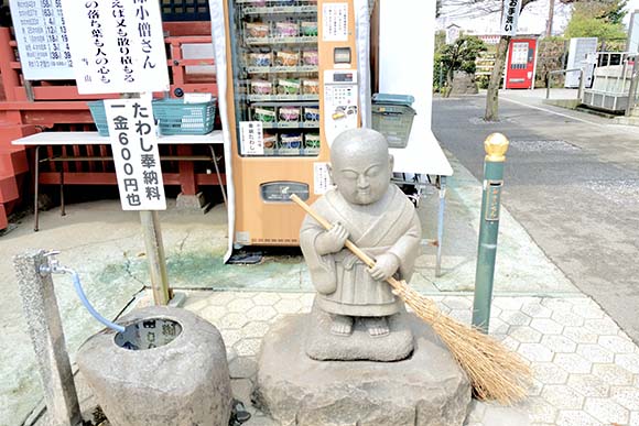 ほうきを持った小僧の石像