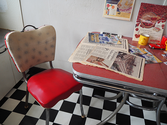 古い新聞が置かれたテーブルと椅子