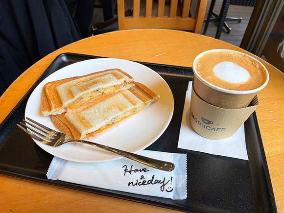 お盆に乗ったホットサンドとホットラテ