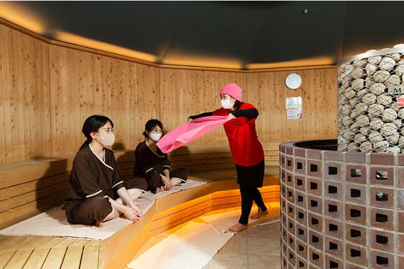 タオルであおぎ熱風をかける女性