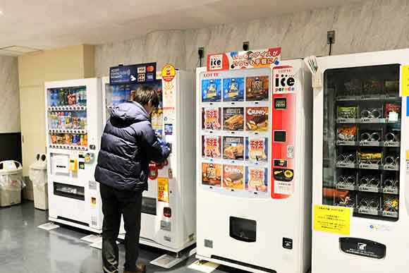 自販機で購入している男性