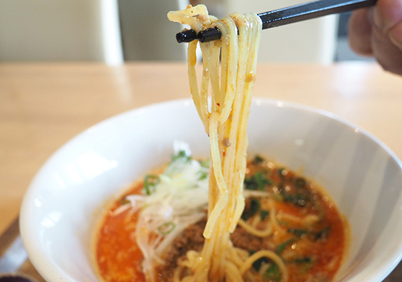 スープの絡んだ麺を持ち上げる