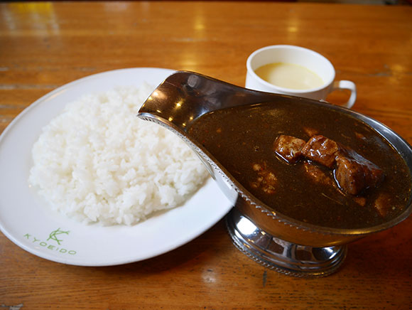 皿に盛られたライスとソースポットのカレー