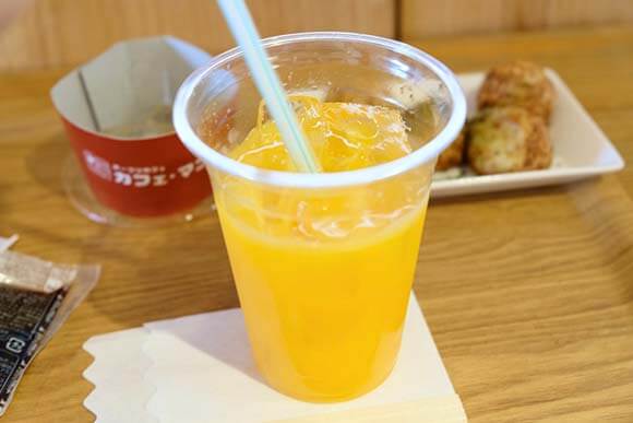 透明なカップに入ったオレンジジュース
