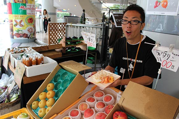 桃の試食をすすめる男性