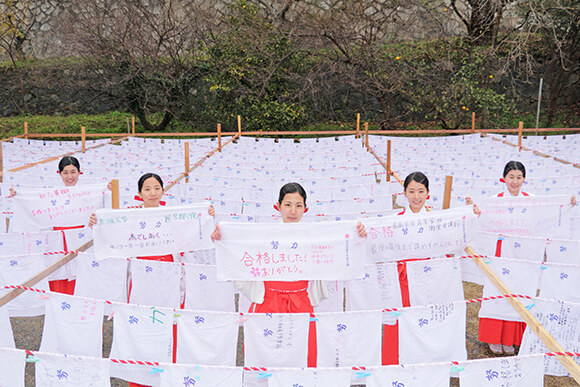 干されたはちまきと笑顔の巫女さん