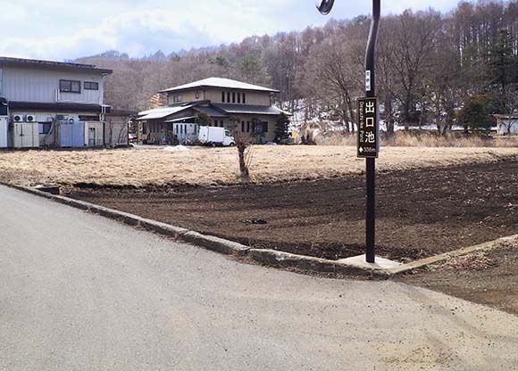 池の案内看板がある道