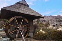 茅葺屋根の建物と水車